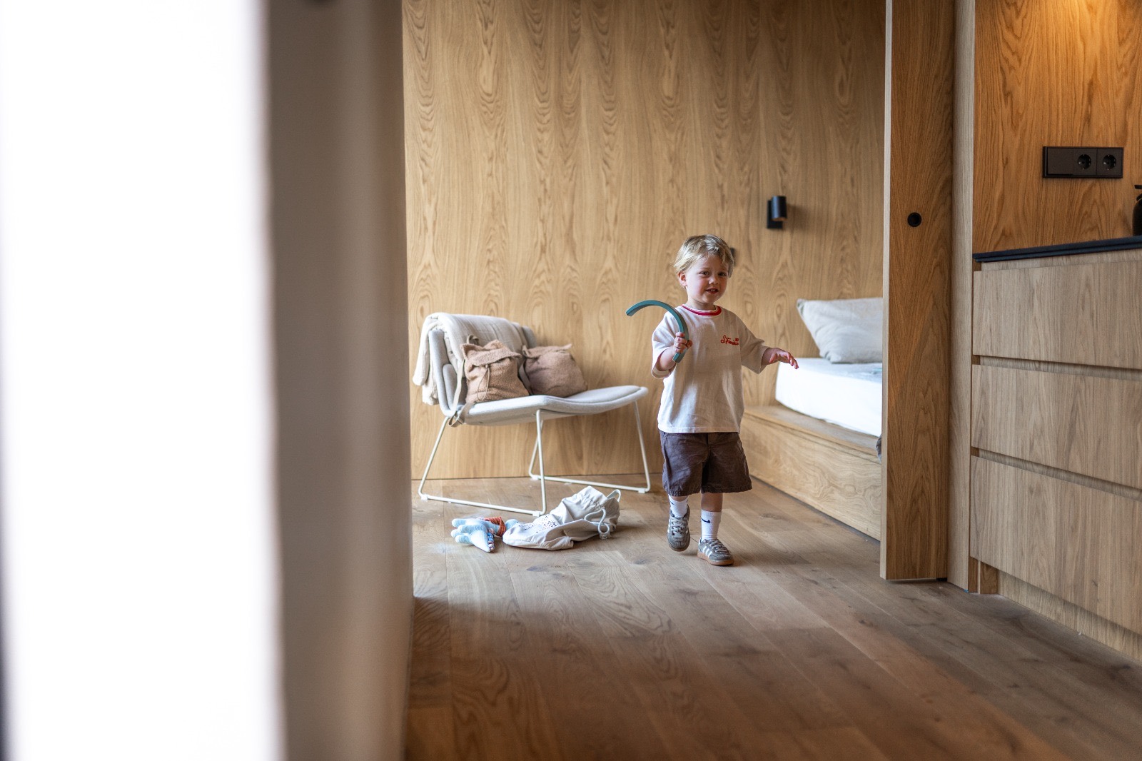 Kind met speelgoed op het bed in de slaapkamer
